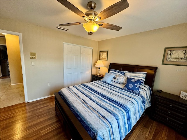 bedroom with ceiling fan, dark hardwood / wood-style floors, and a closet