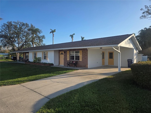 ranch-style house featuring covered porch, a front lawn, and a carport