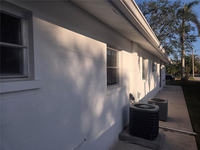 view of side of property featuring a patio and central AC unit