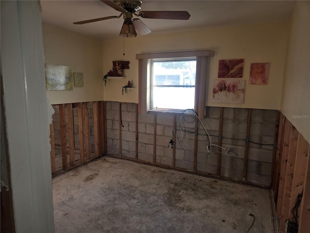 unfurnished room with ceiling fan and concrete flooring