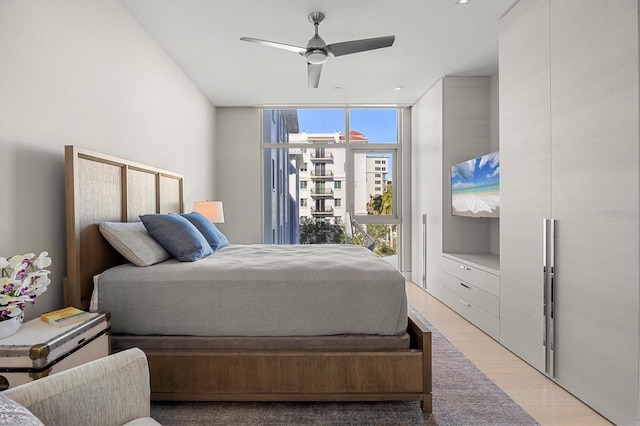 bedroom featuring floor to ceiling windows, ceiling fan, and light hardwood / wood-style flooring