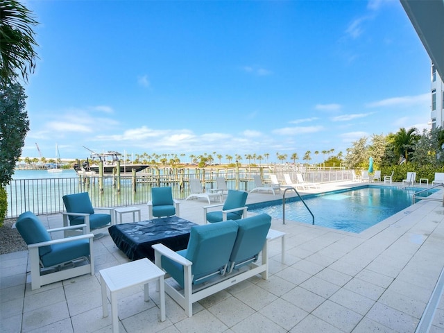 view of swimming pool with a water view and a patio