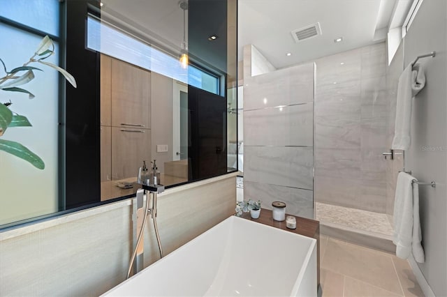 bathroom featuring tile patterned flooring and separate shower and tub