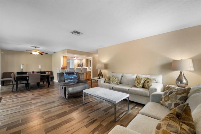 living room with wood-type flooring and ceiling fan