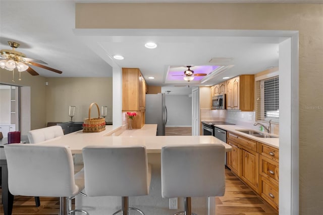 kitchen featuring a kitchen bar, backsplash, sink, and stainless steel appliances