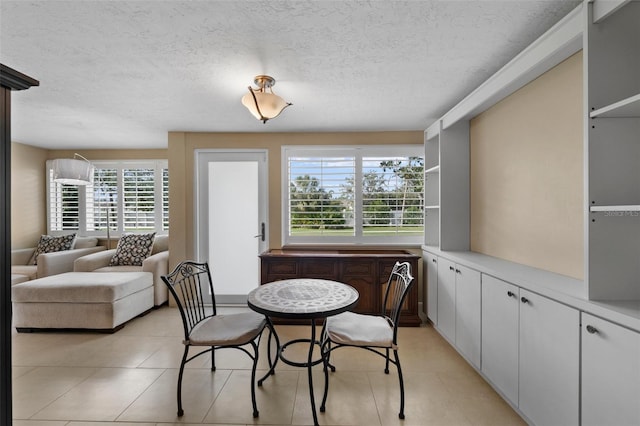 tiled dining space featuring a textured ceiling