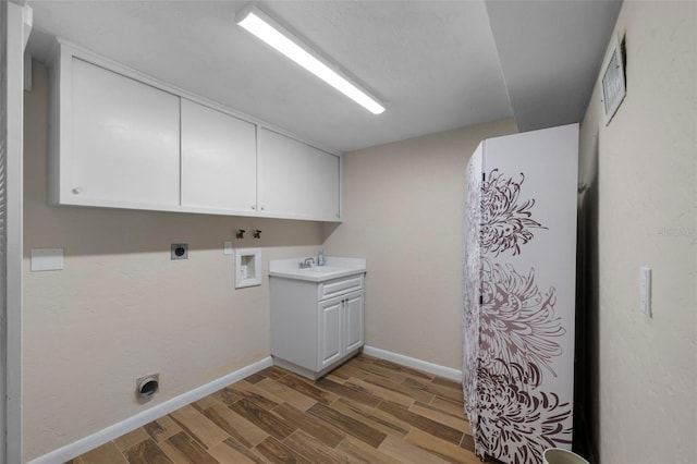 washroom featuring hookup for a washing machine, cabinet space, a sink, electric dryer hookup, and wood finished floors