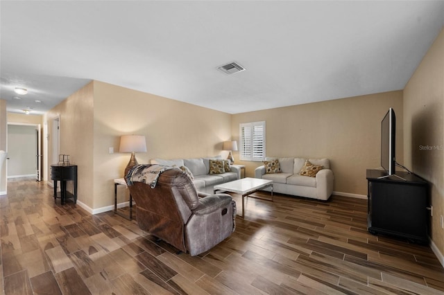 living room with baseboards, visible vents, and wood finish floors