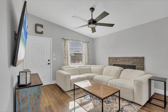 living room featuring a fireplace, ceiling fan, hardwood / wood-style floors, and lofted ceiling