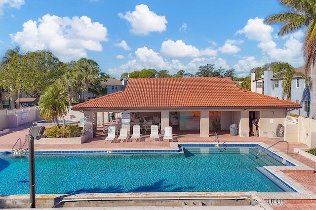 view of pool featuring a patio area and exterior kitchen