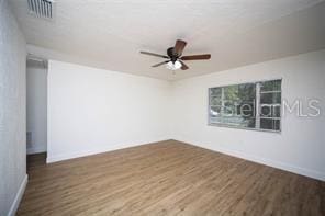 unfurnished room with visible vents, baseboards, a ceiling fan, and wood finished floors