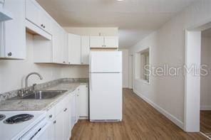 kitchen with white refrigerator, sink, white cabinetry, stove, and wood-type flooring