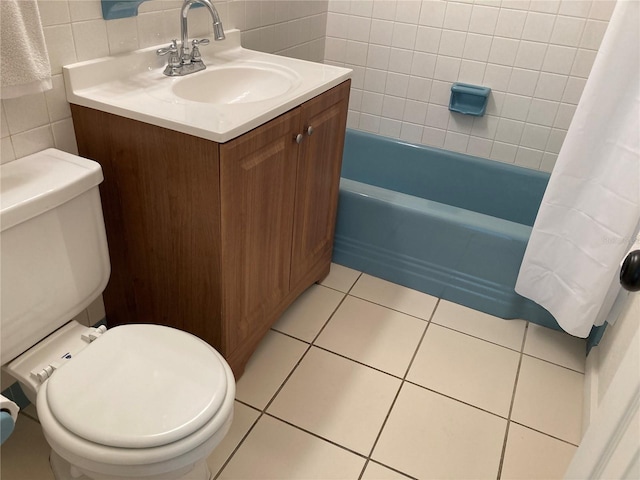 full bathroom featuring shower / bath combination with curtain, toilet, tile patterned floors, vanity, and tile walls