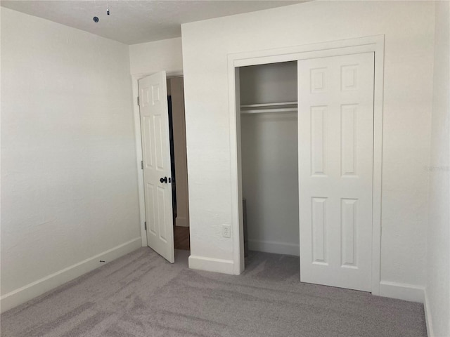 unfurnished bedroom with a closet and light carpet