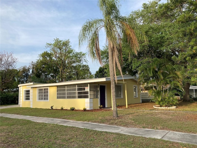 view of front of property featuring stucco siding and a front lawn