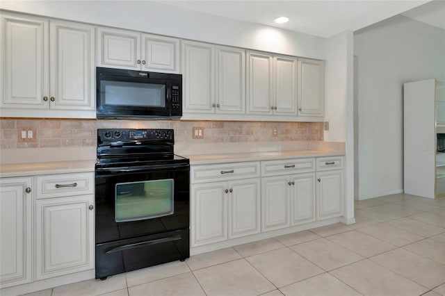 kitchen with black appliances, white cabinets, light tile patterned floors, and tasteful backsplash