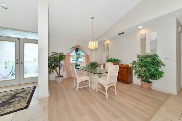 dining space featuring a notable chandelier, french doors, vaulted ceiling, and light hardwood / wood-style flooring