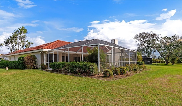 back of house with a lanai and a yard