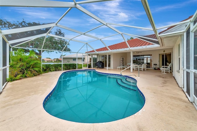 view of pool with glass enclosure, ceiling fan, and a patio