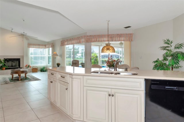 kitchen featuring ceiling fan, sink, light tile patterned floors, black dishwasher, and hanging light fixtures