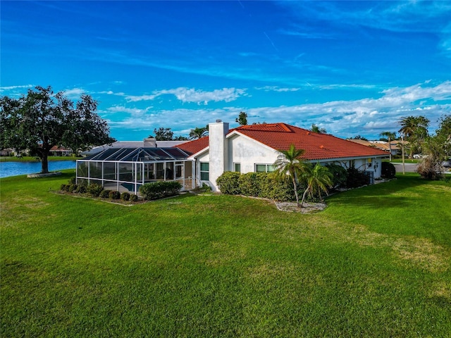 back of property featuring a lawn, glass enclosure, and a water view