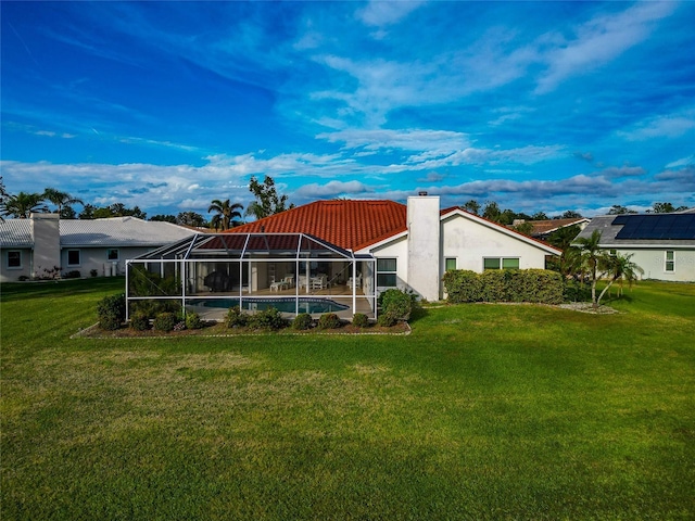 back of house with a yard and a lanai