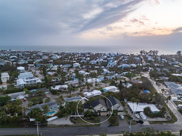 aerial view at dusk featuring a water view