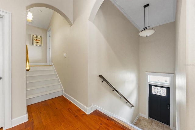 entrance foyer with ornamental molding and hardwood / wood-style flooring