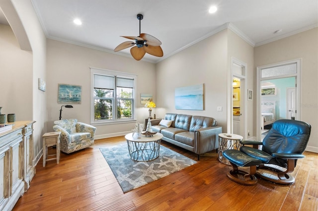 living room featuring ceiling fan, light hardwood / wood-style flooring, and crown molding