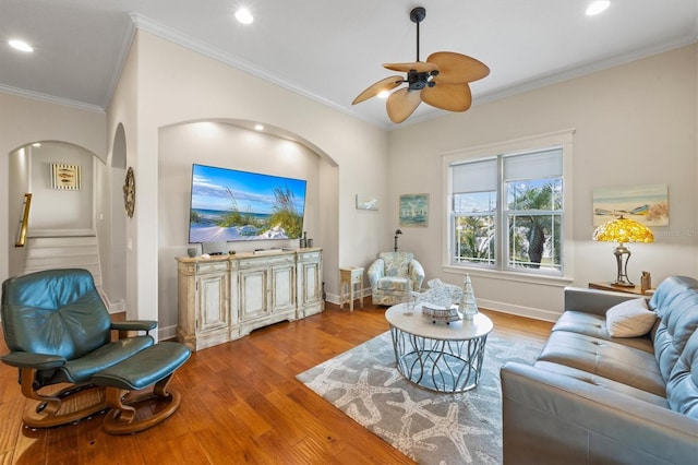 living room featuring ornamental molding, ceiling fan, and light hardwood / wood-style flooring