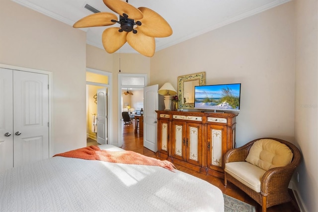 bedroom with wood-type flooring, ceiling fan, crown molding, and a closet