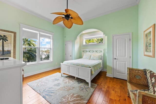 bedroom with ceiling fan, hardwood / wood-style floors, and ornamental molding