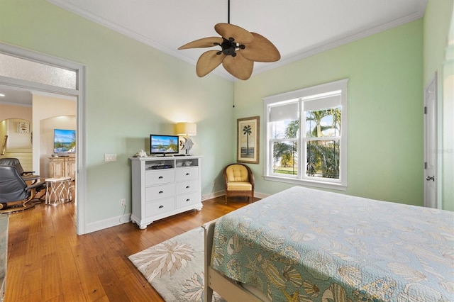 bedroom featuring hardwood / wood-style floors, ceiling fan, and crown molding