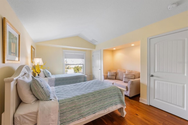 bedroom with lofted ceiling and light hardwood / wood-style flooring