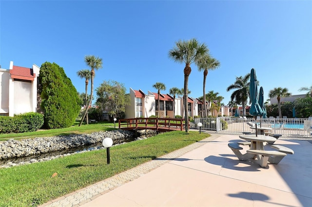 view of community featuring a swimming pool and a lawn