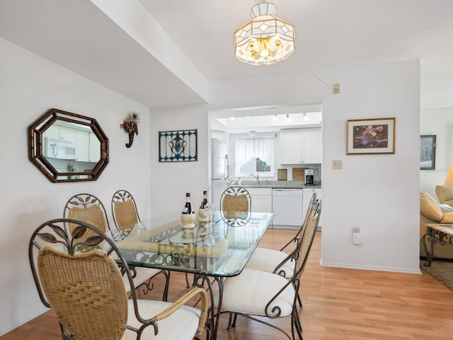 dining room with light wood-type flooring and sink