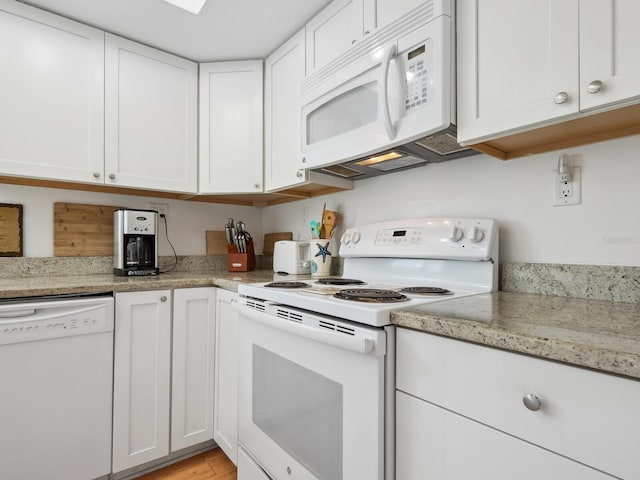 kitchen with white cabinets, white appliances, and light stone counters