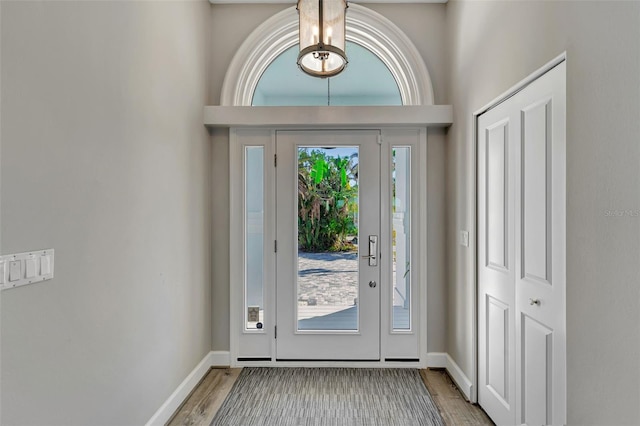 doorway featuring wood-type flooring and a notable chandelier