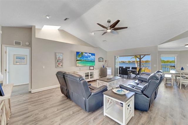 living room with plenty of natural light, ceiling fan, light hardwood / wood-style flooring, and vaulted ceiling