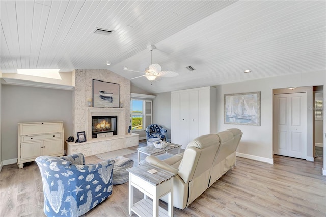 living room featuring a high end fireplace, light wood-type flooring, wood ceiling, vaulted ceiling, and ceiling fan