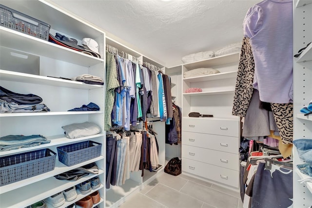 walk in closet with light tile patterned floors