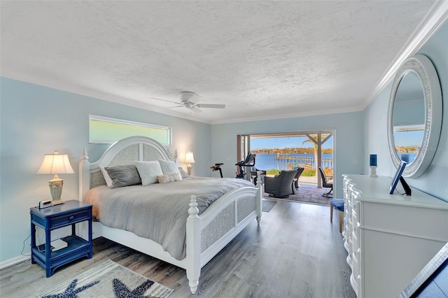 bedroom featuring hardwood / wood-style floors, access to outside, a water view, crown molding, and ceiling fan