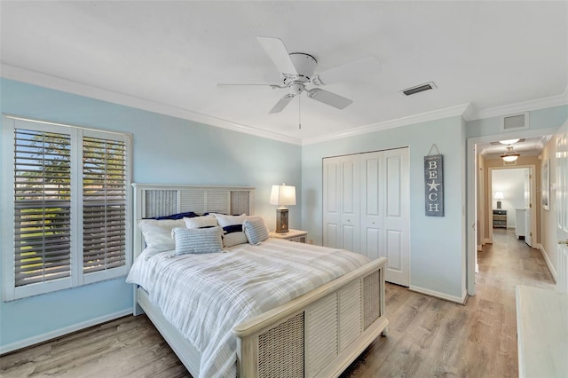 bedroom featuring ceiling fan, a closet, light wood-type flooring, and ornamental molding