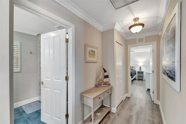 hall featuring light wood-type flooring and ornamental molding