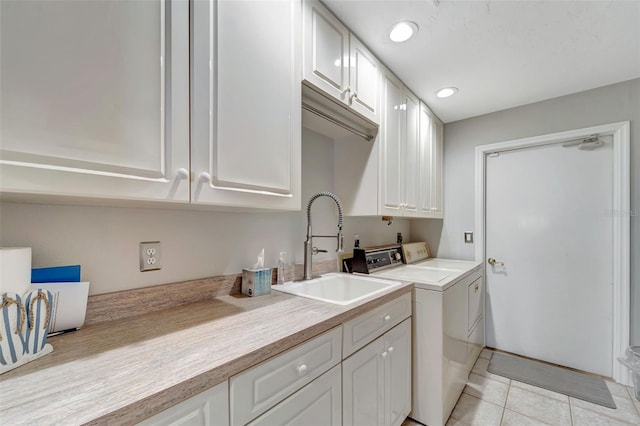 washroom featuring cabinets, light tile patterned floors, separate washer and dryer, and sink