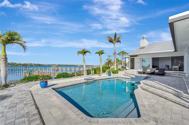 view of pool featuring a patio area and a water view