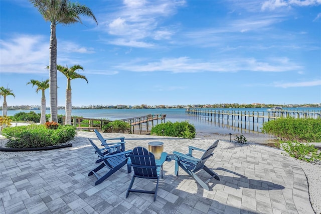 view of patio featuring a water view and a dock