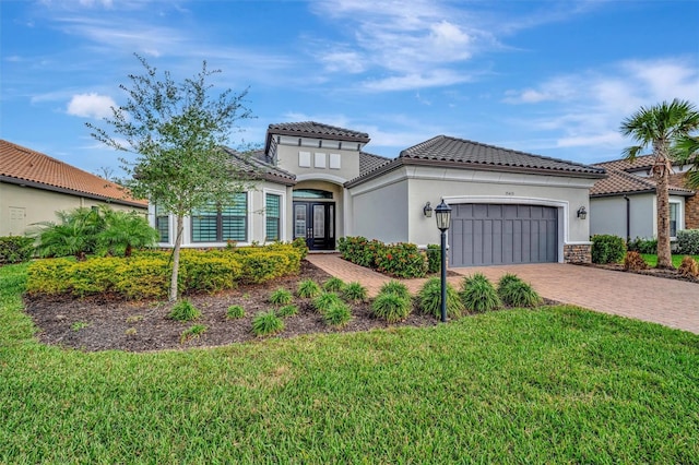 mediterranean / spanish-style home featuring a garage and a front lawn