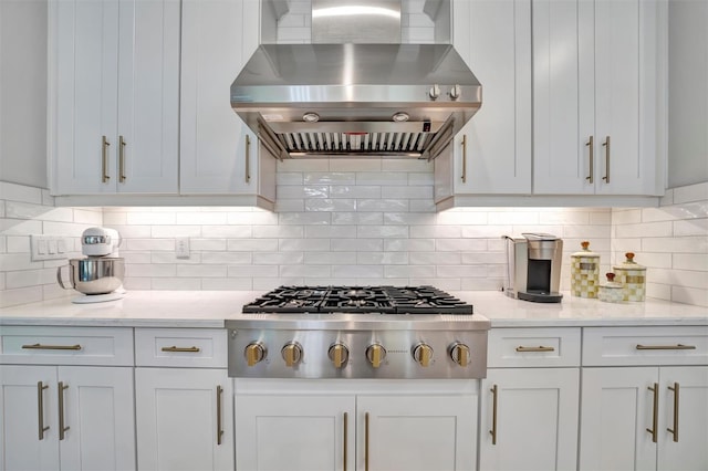 kitchen featuring decorative backsplash, white cabinetry, stainless steel gas cooktop, and wall chimney exhaust hood