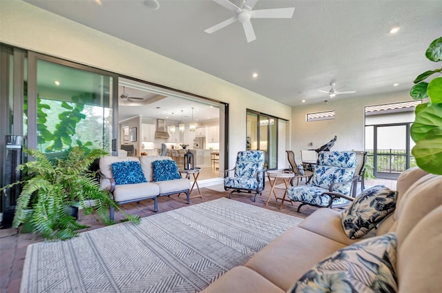 living room with ceiling fan and a textured ceiling